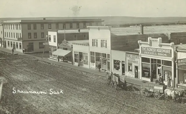 Main Street with Pioneer Hardware and horse-drawn wagons